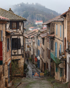 Fotografía urbana de calle antigua con casas de piedra y atmósfera rural europea