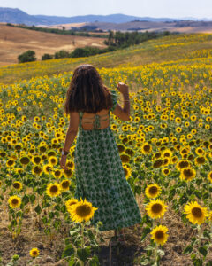 Retrato en ambiente natural, mujer de espaldas rodeada de girasoles en campo rural