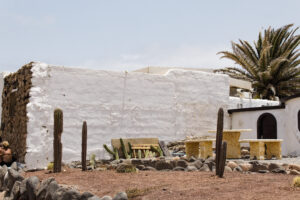 Fotografía de paisaje mediterráneo con arquitectura blanca, cactus y ambiente tranquilo de verano
